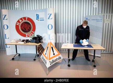 Amburgo, Germania. 16th Dic 2021. Un funzionario doganale presenta la cocaina pressata e altamente concentrata da un grande ritrovamento di cocaina ad una conferenza stampa della dogana di Amburgo. Credit: Christian Charisius/dpa/Alamy Live News Foto Stock