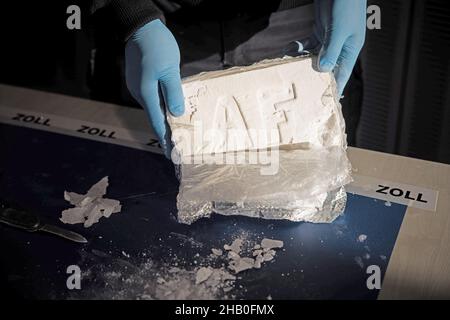 Amburgo, Germania. 16th Dic 2021. Un funzionario doganale presenta la cocaina pressata e altamente concentrata da un grande ritrovamento di cocaina ad una conferenza stampa della dogana di Amburgo. Credit: Christian Charisius/dpa/Alamy Live News Foto Stock