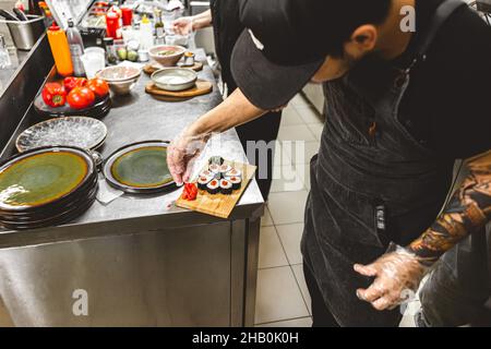 cuochi maschili che preparano il sushi nella cucina del ristorante. Foto Stock
