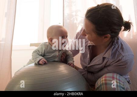 Madre e la sua bambina divertirsi con la palla ginnica. Foto Stock