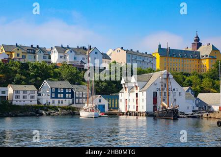 Edifici storici, molo e barche da pesca tradizionali lungo il lungomare del porto, Alesund, Norvegia. Foto Stock