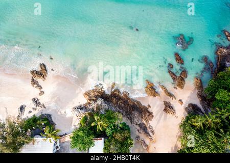 Vista aerea dall'alto bellissima spiaggia d'attualità con palme da cocco e mare di sabbia bianca. Vista dall'alto spiaggia vuota e pulita. Onde che si infrangono spiaggia vuota fr Foto Stock