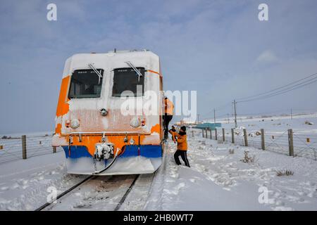 (211216) -- TACHENG, 16 dicembre 2021 (Xinhua) -- lavoratori a bordo di un veicolo di rimozione della neve che corre lungo la ferrovia di Karamey-Tacheng a Tacheng della regione autonoma di Xinjiang Uygur della Cina nord-occidentale, 14 dicembre 2021. Poiché la neve pesante influisce sul funzionamento dei treni in inverno lungo la ferrovia Karamey-Tacheng di tanto in tanto, l'Ufficio ferroviario di Urumqi a Xinjiang ha messo in funzione il veicolo di rimozione della neve migliorato dal dicembre 10 per eliminare la neve accumulata in modo più efficace e garantire il normale funzionamento della ferrovia. (Foto di Bai Fengliang/Xinhua) Foto Stock