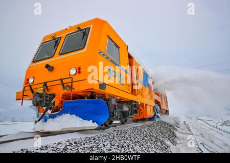 (211216) -- TACHENG, 16 dicembre 2021 (Xinhua) -- Un veicolo di rimozione della neve corre lungo la ferrovia di Karamey-Tacheng in Tacheng della regione autonoma di Xinjiang Uygur della Cina nord-occidentale, 14 dicembre 2021. Poiché la neve pesante influisce sul funzionamento dei treni in inverno lungo la ferrovia Karamey-Tacheng di tanto in tanto, l'Ufficio ferroviario di Urumqi a Xinjiang ha messo in funzione il veicolo di rimozione della neve migliorato dal dicembre 10 per eliminare la neve accumulata in modo più efficace e garantire il normale funzionamento della ferrovia. (Foto di Bai Fengliang/Xinhua) Foto Stock