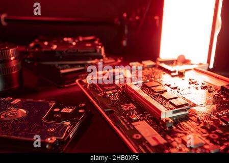 Computer smontato sul tavolo del riparatore con vari pezzi e componenti pronti per la sostituzione. Riparazione elettronica tavolo. Repa. Computer di casa Foto Stock