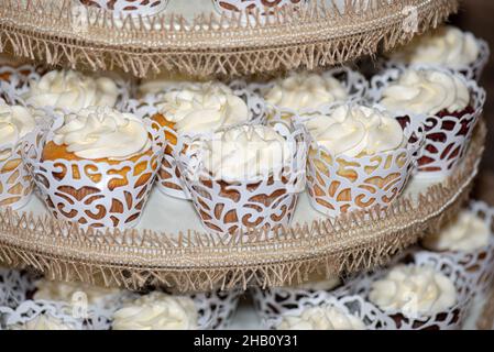 La torre dei cupcake glassati alla vaniglia al bar dessert durante il matrimonio Foto Stock