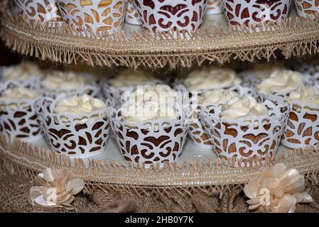 La torre dei cupcake glassati alla vaniglia al bar dessert durante il matrimonio Foto Stock