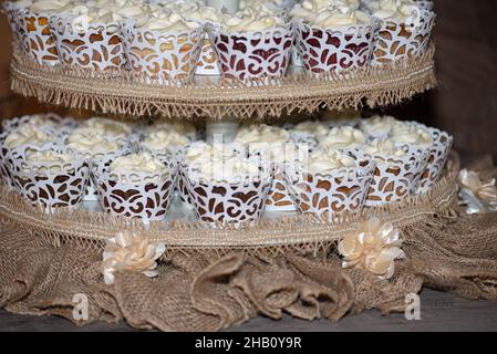 La torre dei cupcake glassati alla vaniglia al bar dessert durante il matrimonio Foto Stock