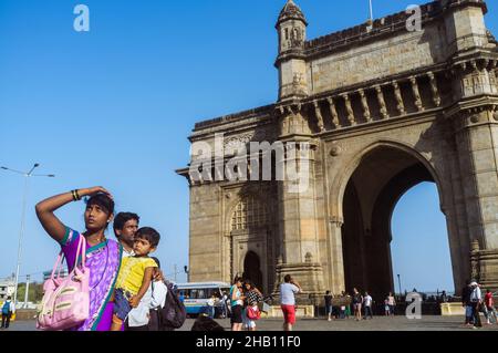 Mumbai, Maharashtra, India : una donna indiana si trova accanto alla porta d'India arco monumentale costruito tra il 1913 e il 1924 nello stilista Indo-Saracenico Foto Stock