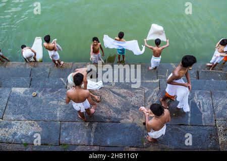 Udupi, Karnataka, India : i giovani novizi del brahmin lavano i loro vestiti al serbatoio dell'acqua di Madhva Sarovara adiacente al tempio di Krishna del 13th secolo. Il Foto Stock