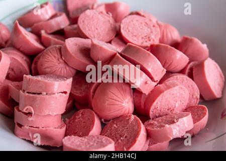 Affettato salsiccia cruda, primo piano salsiccia non cotti in un piatto. Foto Stock