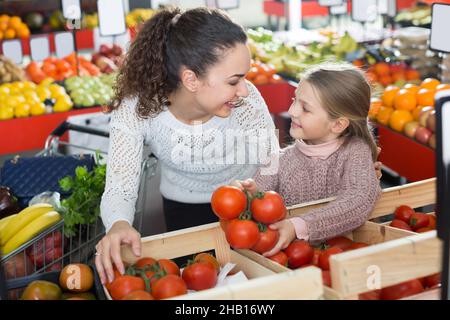 Ritratto di mamma e ragazza giovane acquisto pomodoro Foto Stock