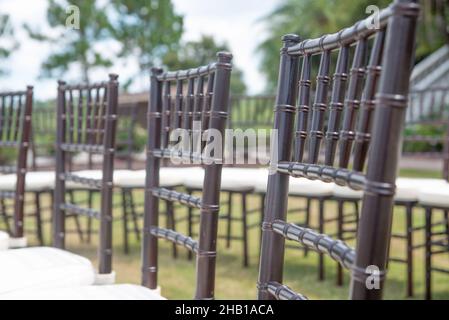 Unica cerimonia nuziale con motivo a spirale, ambientata nella campagna delle colline ondulate, con sedie chiavari marroni e cuscini bianchi Foto Stock