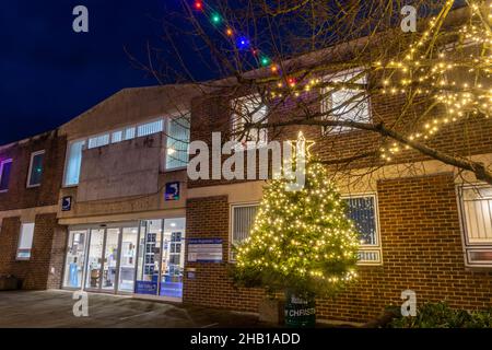 Dicembre 15th, 2021. Il centro di Romsey, nell'Hampshire, nel Regno Unito, è stato decorato e illuminato con luci natalizie colorate. Nella foto è raffigurato il Test Valley Borough Council Office building e albero di Natale. Foto Stock