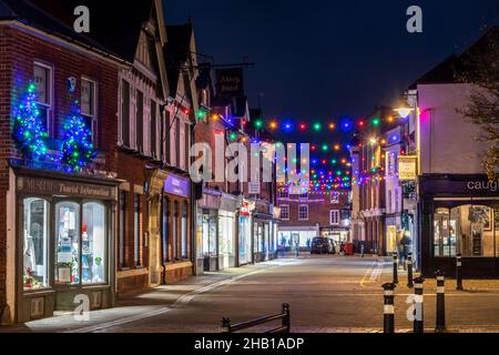 Dicembre 15th, 2021. Il centro di Romsey, nell'Hampshire, nel Regno Unito, è stato decorato e illuminato con luci natalizie colorate. Nella foto è presente Bell Street. Foto Stock