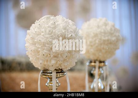 Centratura del tavolo in oro con fiori di palla bianchi con diamanti al ricevimento di nozze Foto Stock