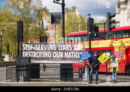 L’Unione pro-europea (UE), gli attivisti anti-Brexit tengono cartelloni accanto a una bandiera a Westminster, nel centro di Londra. Foto Stock