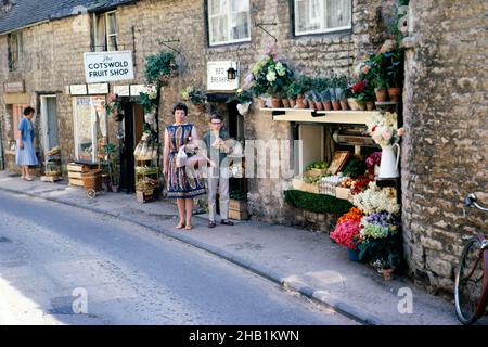 Stow-on-the-Wold, Gloucestershire, Inghilterra in 1963 donne e ragazzi posano fuori Cotswold Fruit Shop Foto Stock