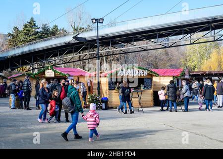 Bucarest, Romania - 28 Novembre 2021: Le persone che godono di bevande tradizionali di hod, cibo e dolci al mercato di Natale nel Parco Drumul Taberei (tamburo di Parcul Foto Stock