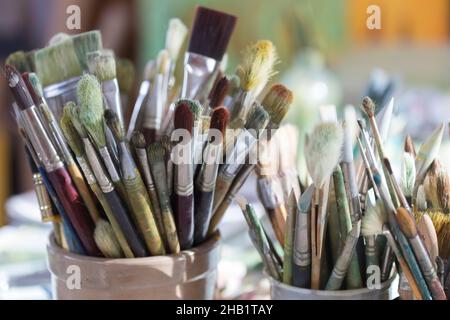 Selezione di pennelli dell'artista in contenitori di ceramica Foto Stock