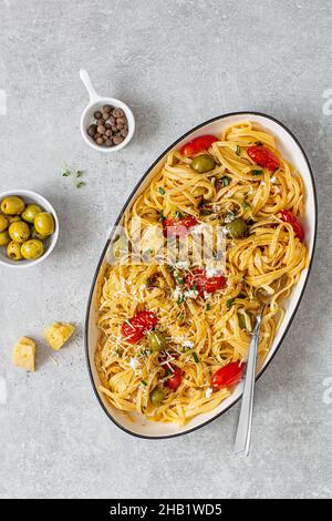 pasta con pomodori ciliegini, olive e chesee parmigiano a tavola Foto Stock