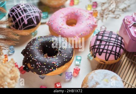 I vari colori e degustare ciambelle smaltate sul tavolo Foto Stock