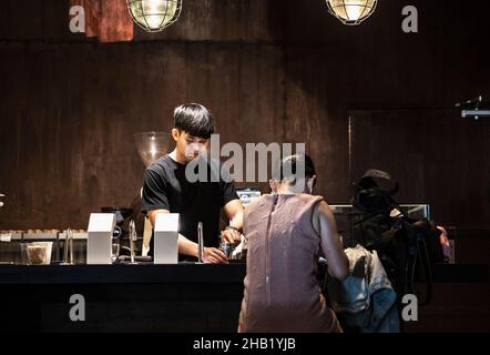 Il barista prepara il caffè all'Hipster Cafe di Bangkok Foto Stock