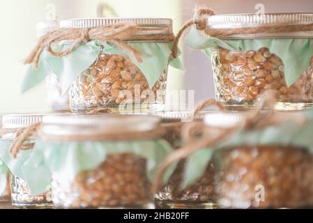 I chicchi di popcorn sono impilati in vasetti di vetro con cime verdi al dessert bar Foto Stock