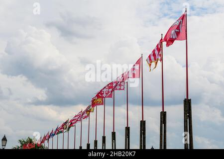Molte bandiere colorate e vivide che soffiano nel vento in diretta luce solare verso il cielo blu chiaro in una giornata di sole vicino al Castello di Buda a Budapest, Ungheria Foto Stock