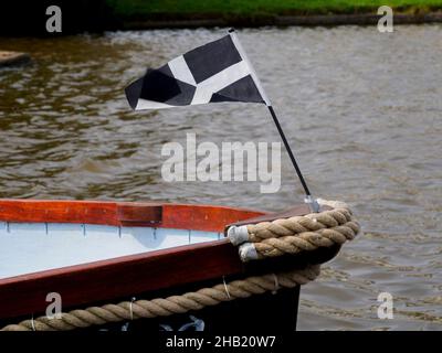 La bandiera della Cornovaglia (St Piran's) che vola sulla prua di una barca, Bude, Cornovaglia, Regno Unito Foto Stock