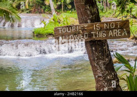 Cartello in legno il turista non è permesso questa zona a Cambugahay Falls sull'isola di Siquijor, Filippine. Foto Stock