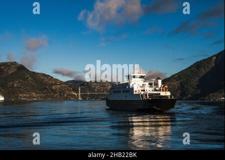 Bellissimo paesaggio di rocce enormi e Lusefjord. Ponte sul fiordo. Una nave galleggiante. Foto Stock