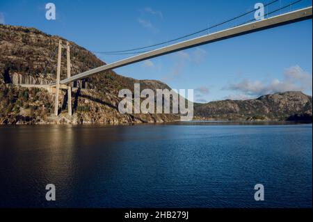 Paesaggio panoramico del Lusefjord. Cielo blu e acqua. Rocce enormi. Ponte sul fiordo. Bella natura della Norvegia. Foto Stock