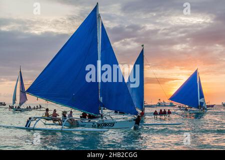 BORACAY, FILIPPINE - 1 FEBBRAIO 2018: Tramonto con barche a vela al largo della spiaggia bianca sull'isola di Boracay, Filippine Foto Stock