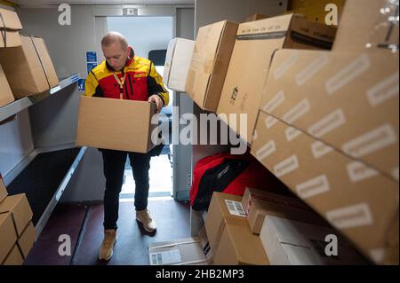 Ober Ramstadt, Germania. 15th Dic 2021. Un dipendente DHL ordina i pacchi nel suo furgone per le consegne successive. (A dpa 'i deliverers effettuano milioni di pacchi prima di Natale') credito: Sebastian Gollnow/dpa/Alamy Live News Foto Stock