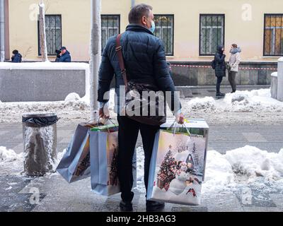 Mosca, Russia. 14th Dic 2021. Un uomo che porta pacchetti vacanza di Capodanno visto dopo lo shopping al Central Children's Store di Lubyanka (Foto di Alexander Sayganov/SOPA Images/Sipa USA) Credit: Sipa USA/Alamy Live News Foto Stock