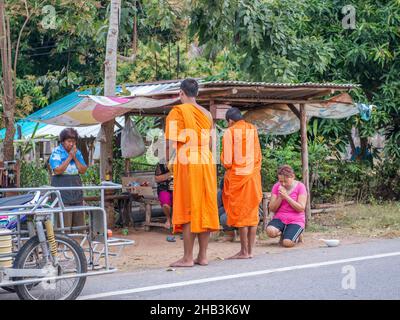 Monaci buddisti che ricevono elemosina da donne thailandesi al mattino presto a Sam Roi Yot a sud di Hua Hin in Thailandia. Foto Stock