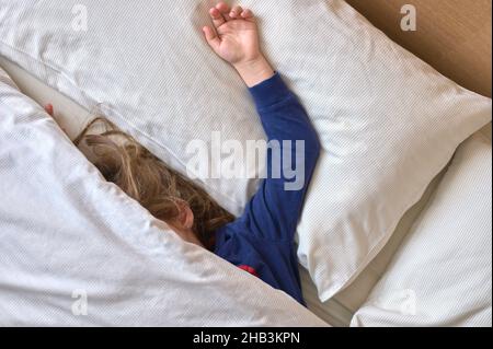 particolare di una ragazza che dorme in un letto coperto da una trapunta Foto Stock