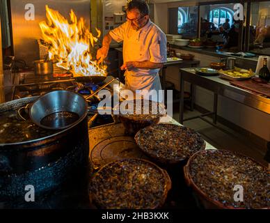 Lo chef Eric Rousselot prepara il famoso Cassoulet Imperial all'Hostellerie Etienne, un'azienda a conduzione familiare dal 1956. Labastide d'Anjou, Francia. Il calore e il tempo sono due componenti importanti per la deliziosa cassoulet della Francia meridionale Foto Stock