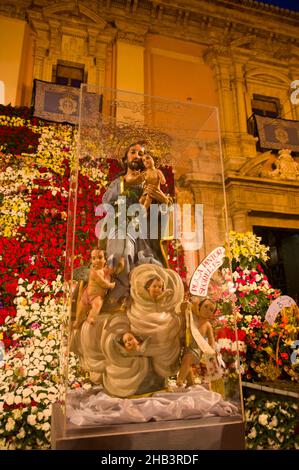 Marzo, 2016. Valencia, Spagna. Primo piano dell'immagine di San Giuseppe accanto all'offerta dei fiori alla Virgen de los Desamparados durante la Falla Foto Stock