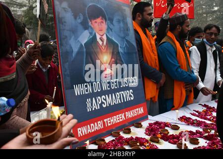 Lahore, Pakistan. 16th Dic 2021. Attivisti pakistani di Rawadari Tehreek illuminando le candele durante la cerimonia di accensione delle candele in ricordo dei Martiri insegnanti e studenti della Scuola pubblica dell'Esercito (APS) incidente di Peshawar a Lahore. Un attacco alla Scuola pubblica dell'Esercito (APS) nella città di Peshawar, dove più di 150 studenti sono stati uccisi quando i cannonieri talebani hanno superato il 16 dicembre 2014. (Foto di Rana Sajid Hussain/Pacific Press) Credit: Pacific Press Media Production Corp./Alamy Live News Foto Stock