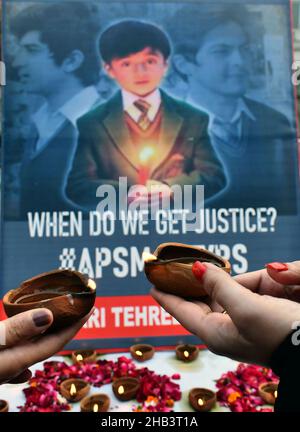 Lahore, Pakistan. 16th Dic 2021. Attivisti pakistani di Rawadari Tehreek illuminando le candele durante la cerimonia di accensione delle candele in ricordo dei Martiri insegnanti e studenti della Scuola pubblica dell'Esercito (APS) incidente di Peshawar a Lahore. Un attacco alla Scuola pubblica dell'Esercito (APS) nella città di Peshawar, dove più di 150 studenti sono stati uccisi quando i cannonieri talebani hanno superato il 16 dicembre 2014. (Foto di Rana Sajid Hussain/Pacific Press) Credit: Pacific Press Media Production Corp./Alamy Live News Foto Stock