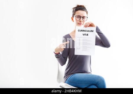 Giovane donna seduto mostrando un ben fatto riprendere, AKA corrucoulum vitae, il che significa che assumono e si può fare domanda per un buon e gratificante lavoro Foto Stock