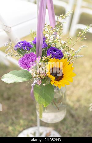 Girasole e rose di puple in vaso di mason decorazione floreale all'isola di nozze Foto Stock