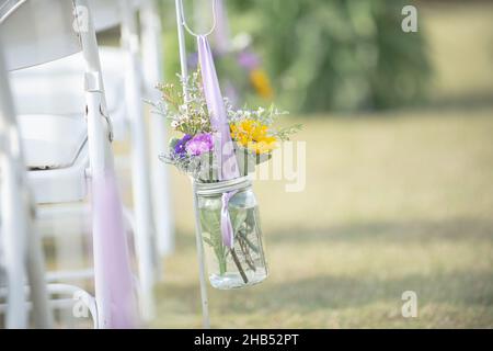 Girasole e rose di puple in vaso di mason decorazione floreale all'isola di nozze Foto Stock