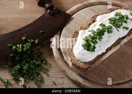 altes Wiegemesser mit Lauch, Kräuterquark und Brot Foto Stock