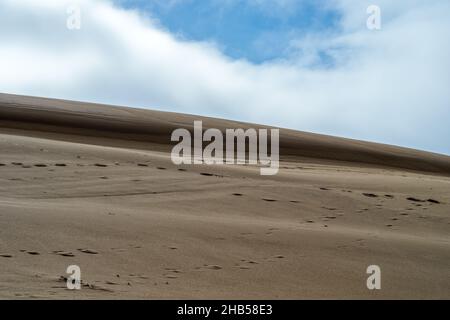 Nuvole che si aprono sopra creste nelle dune di sabbia lungo il John Dellenback Trail vicino Lakeside, Oregon, USA Foto Stock
