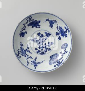 Piatto-piattino con polvere blu, fiori spray, simboli propiziosi e oggetti preziosi, Salsetta di porcellana con parete arrotondata, dipinto in blu smalto con poudré bleu. Sul piatto un medaglione con ramo di peonia; sul muro un ramo di prunus, crisantemo, peonia e camelia; il bordo con motivo geometrico; il dorso è coperto di bleu poudré (blu polvere) con incisi simboli di buon auspicio (ombrellone, guscio), oggetti di valore (foglia di artemisia) e antichità (scroll). Contrassegnato sul lato inferiore con il marchio a sei caratteri dell'imperatore Chenghua. Sei chip al confine. Bleu poudré con blu e. Foto Stock