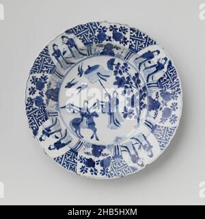 Piatto con le donne in giardino recintato e piante fiorite in prossimità di una roccia, piatto profondo di porcellana con bordo lobato, dipinto in blu underglaze. Sull'appartamento in un medaglione una donna (long lijs) su un cavallo in un giardino recintato. Di fronte c'è una donna, la sua mano sollevata in un gesto di saluto. Dietro di lei una serva con un ombrellone. Sopra di loro volano tre uccelli. Il muro e il bordo con otto vani lobati alternati tra due donne in un giardino recintato o piante fiorite vicino ad una roccia. Tra i tocchi un motivo di swastika e archi. Il bordo esterno con sei viti da fiore. La parete esterna con motivi ruyi Foto Stock