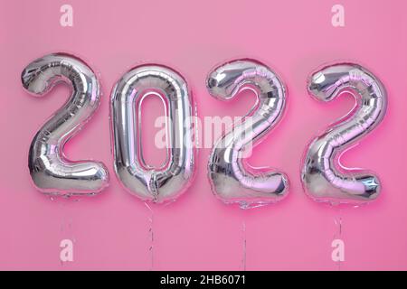 Da sopra numero palloncini Capodanno 2022 oggetto rendere ballon con nastro rosa sfondo Foto Stock